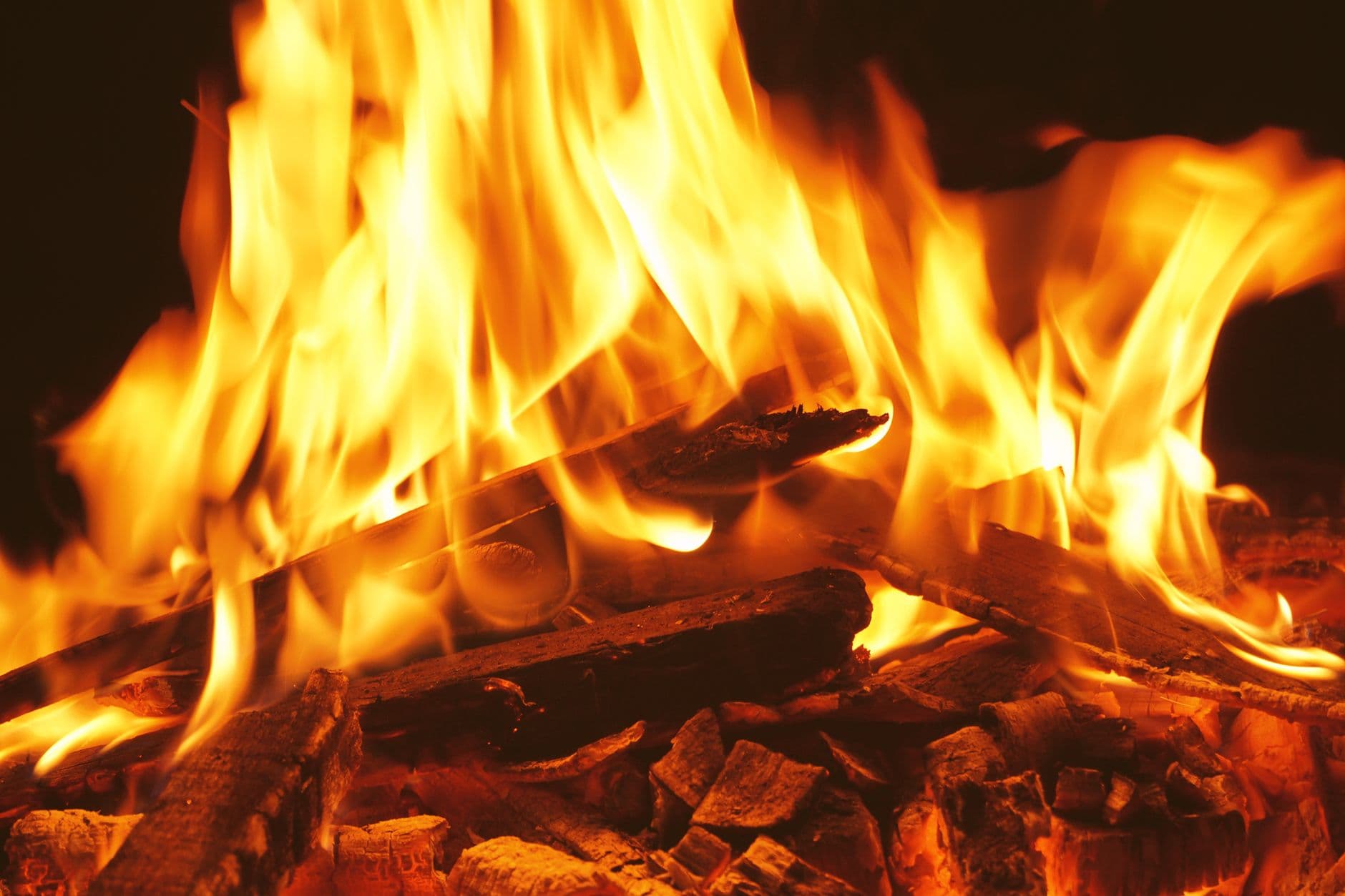 Detailed image of a campfire with intense, bright flames and burning wood.