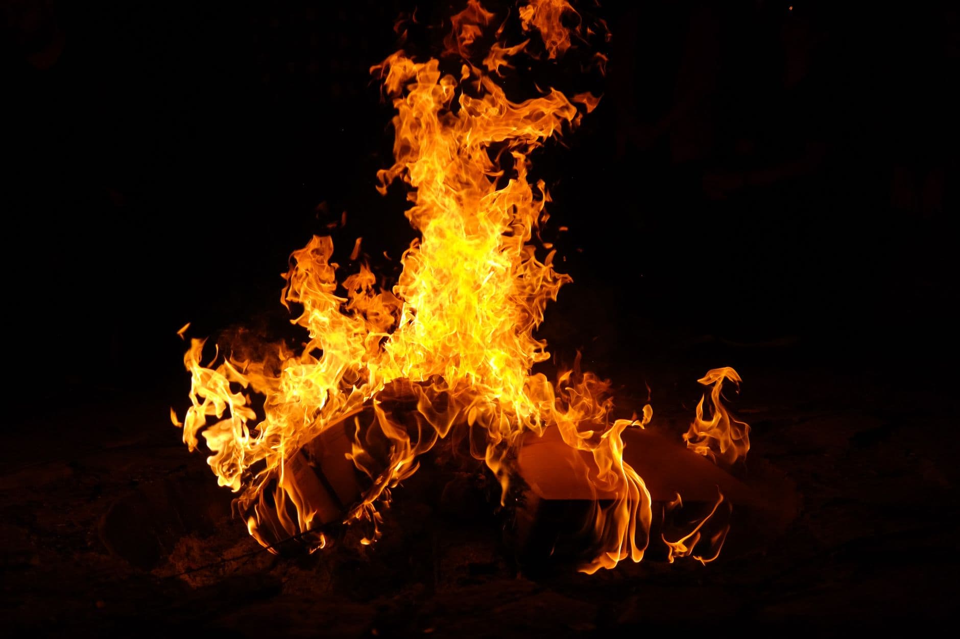 A mesmerizing campfire with bright orange flames against a black background, perfect for outdoor-themed designs.